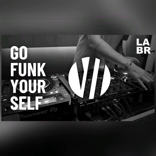 Black & White Photo. Witton over a Pioneer DJ System set up. Right hand on left deck. Bracelet on wrist of right hand. Short sleeved shirt. In white letters, his show title. Go Funk Yourself. Upper right hand side is the LABR logo in white blocked letters. LA on top BR on the bottom.