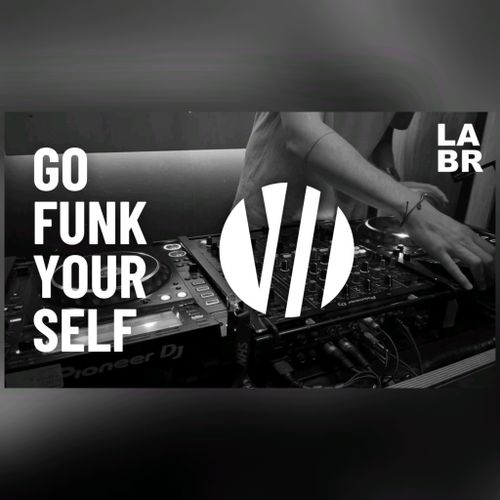 Black & White Photo. Witton over a Pioneer DJ System set up. Right hand on left deck. Bracelet on wrist of right hand. Short sleeved shirt. In white letters, his show title. Go Funk Yourself. Upper right hand side is the LABR logo in white blocked letters. LA on top BR on the bottom.